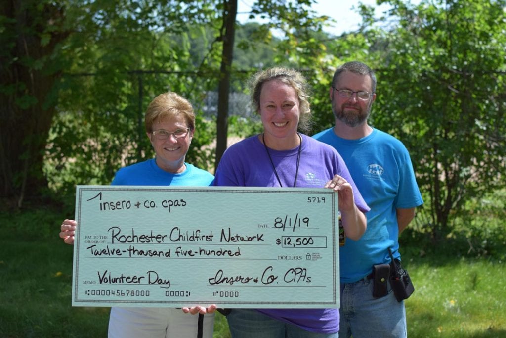 Nancy Catarisano presents a check to Ann Marie Stephan of Rochester Childfirst Netowrk on Volunteer Day