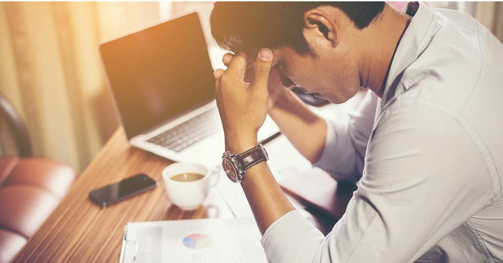 man with laptop frustrated over dissolving a business