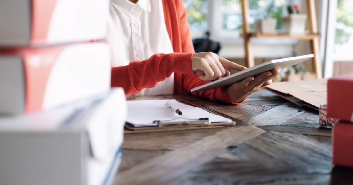 PayPal Phishing woman on tablet with list and boxes on desk