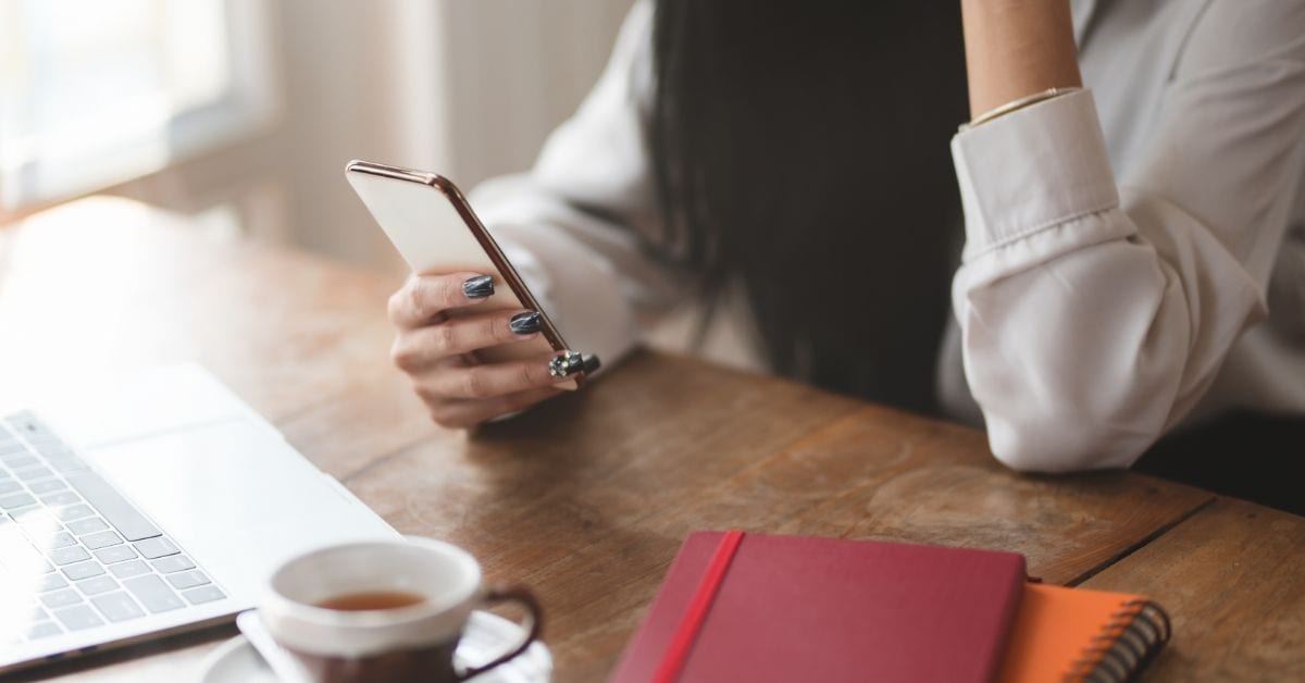 woman on phone with computer and note book doing donor relations