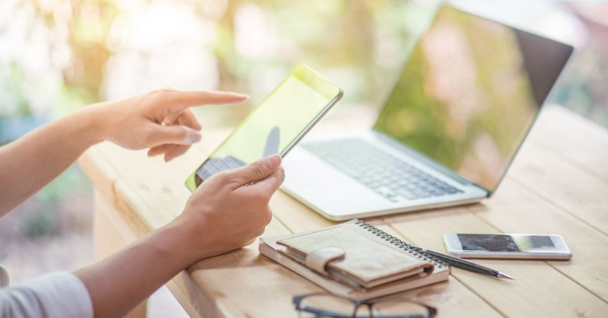 woman on tablet with computer on table