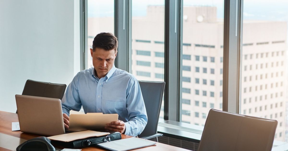 man looking at a folder in his office