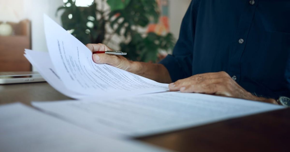 Businessman in casual clothes reviewing document reports