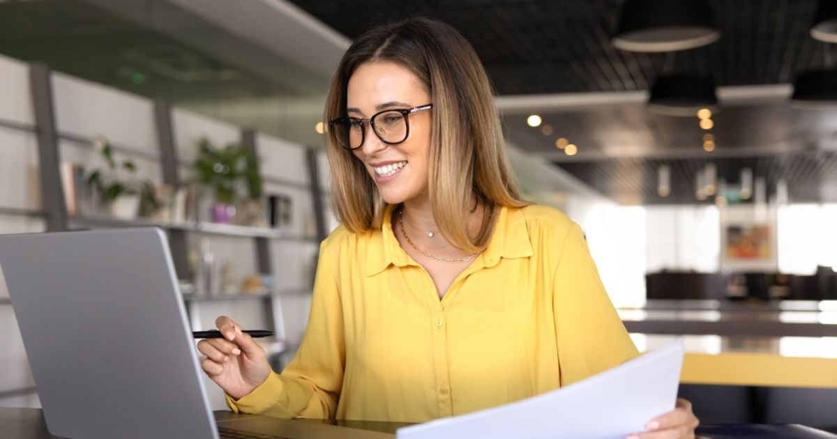 young accountant woman in glasses analyzing paper financial report
