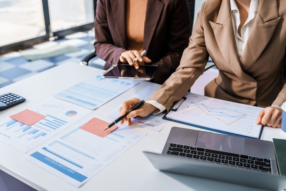 female business professionals in suits sit at desk